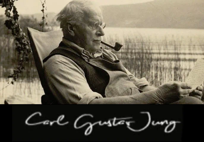 Carl Gustav Jung lendo a beira de lago, com cachimbo na boca.